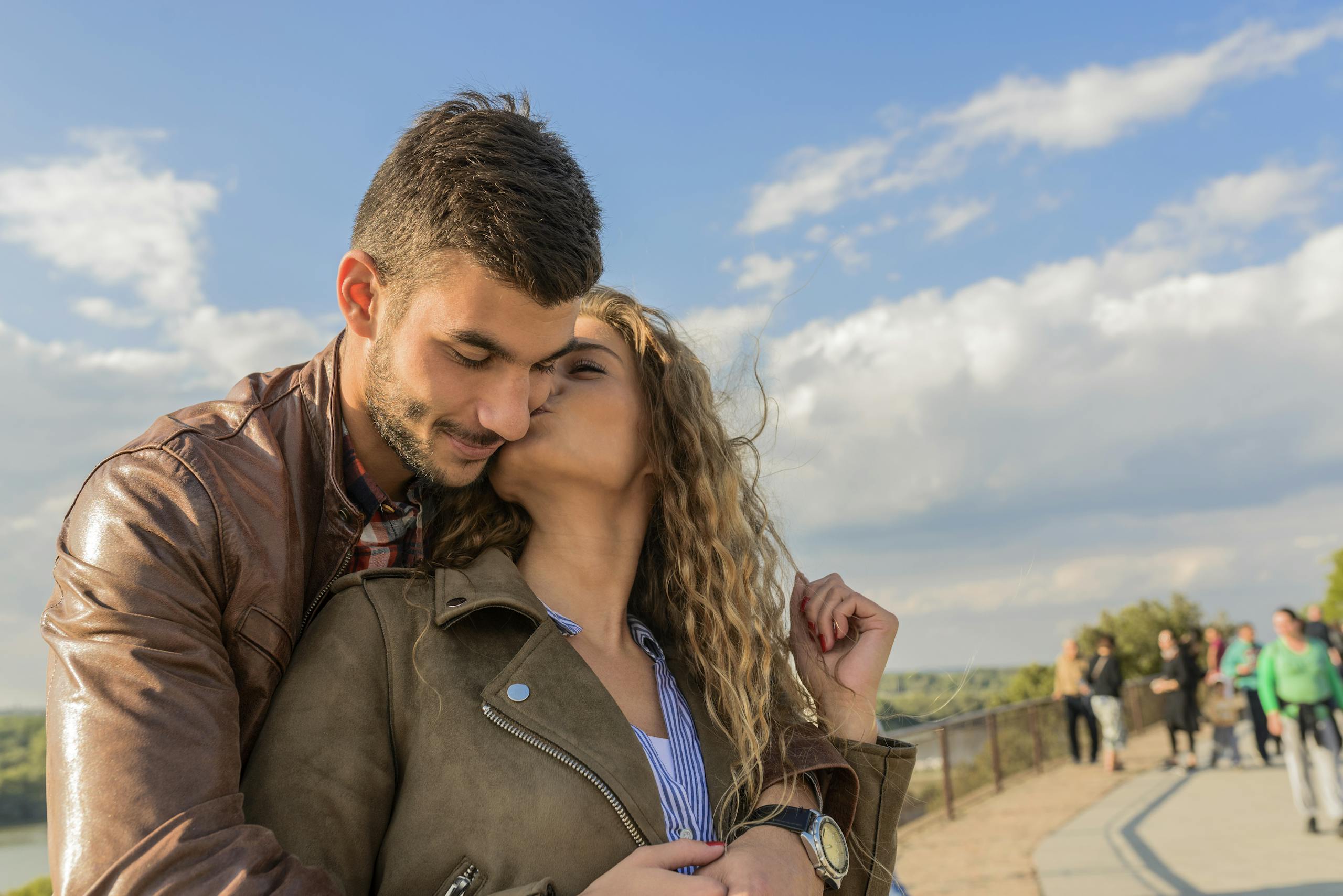 A loving couple embraces under a clear sky, showcasing romance and togetherness.